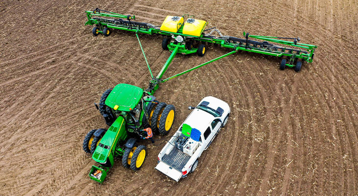 tractor and truck in a field planting.