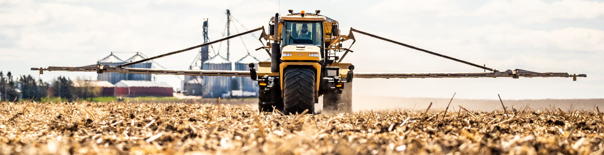 Tractor carrying a sprayer