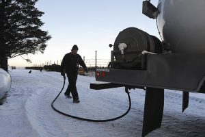 Man walking hose back to back of propane truck