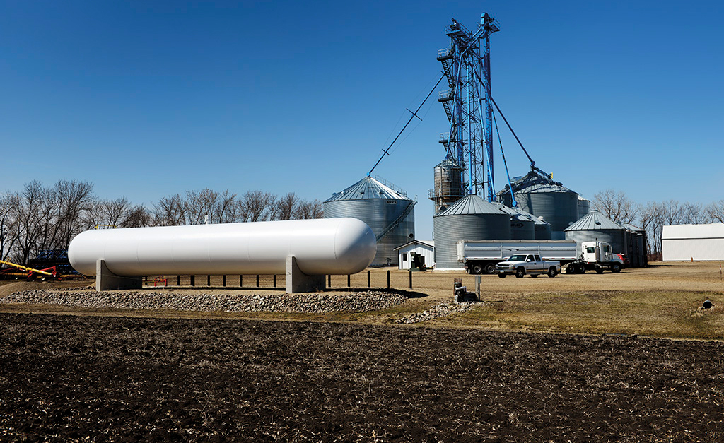 Propane tank with grain bins in the background